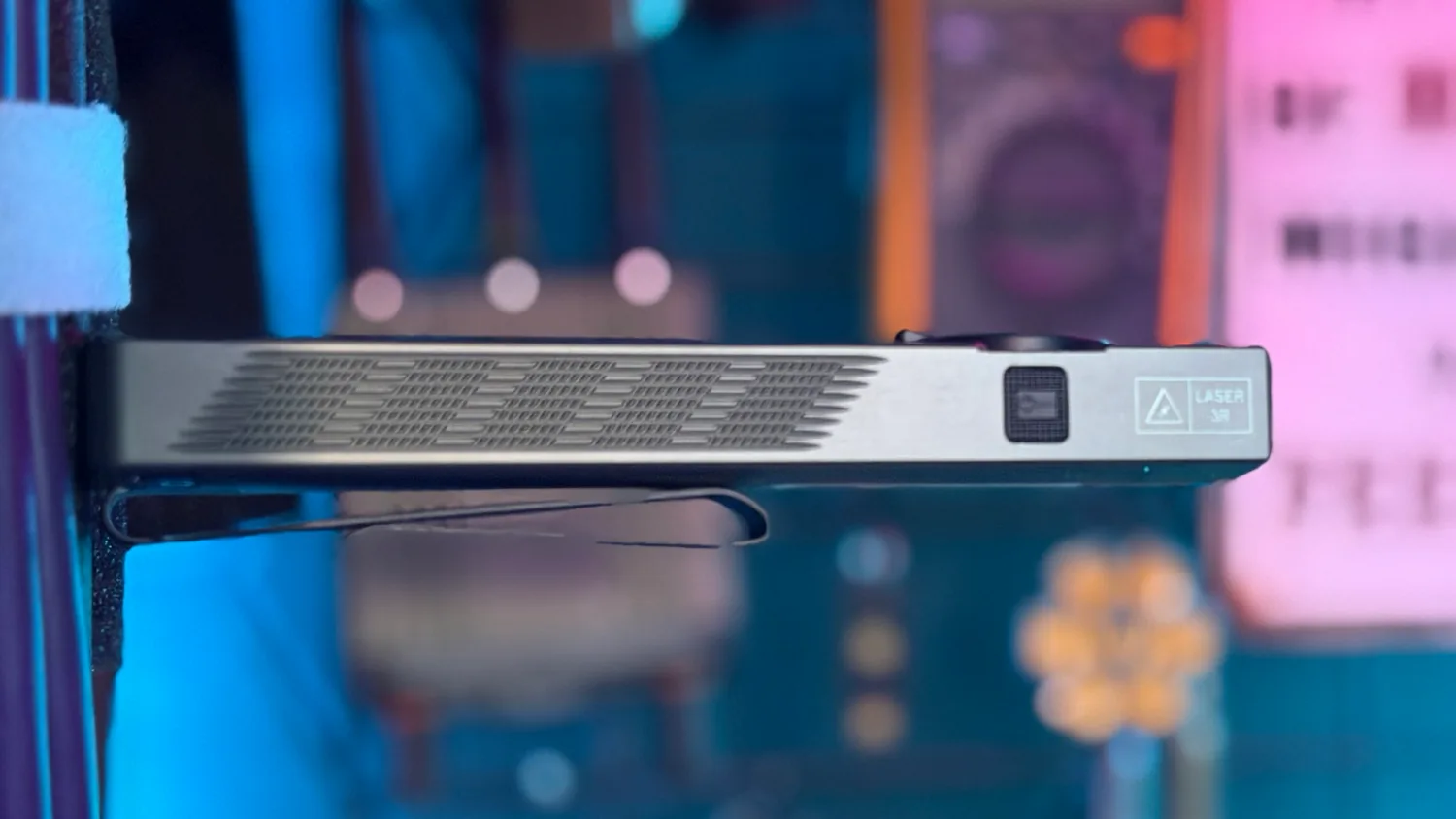 Side profile of the Olight ArkPro showing the cooling fins, laser button, and LASER 3R marking